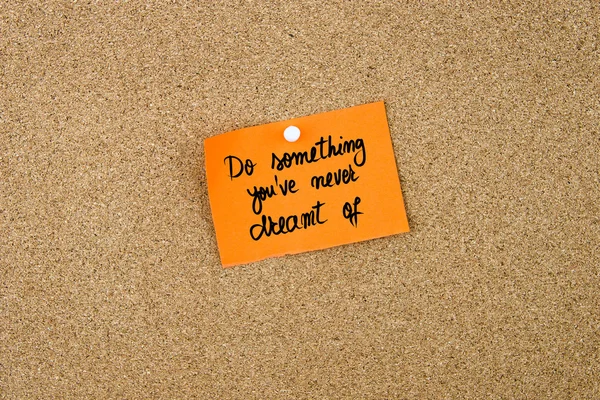 Do Something You 've Never Dreamt of written on orange paper note — стоковое фото