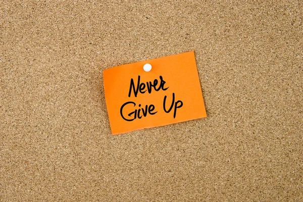 Nooit Give Up geschreven op oranje papier opmerking — Stockfoto