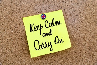 Yellow paper note pinned with Great Britain flag thumbtack and text KEEP CALM AND CARRY ON