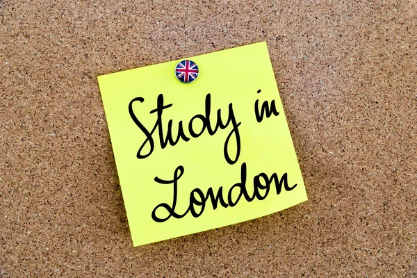 Yellow paper note pinned with Great Britain flag thumbtack and text Study In London — Stock fotografie