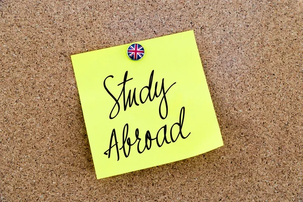 Yellow paper note pinned with Great Britain flag thumbtack and text Study Abroad — Stock fotografie