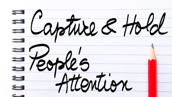 Capture and Hold Peoples Attention Note written on notebook page