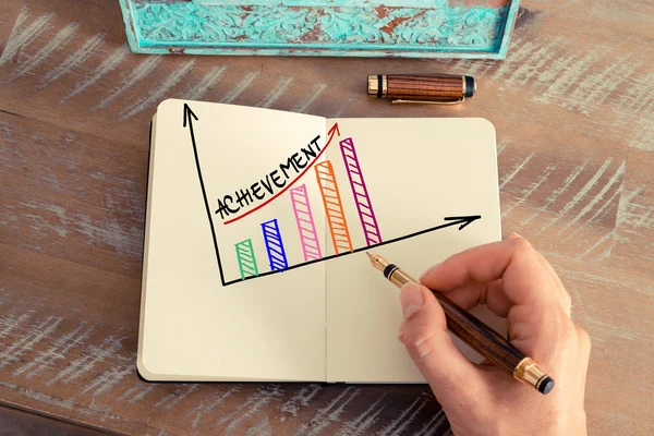 Business woman drawing a colourful ACHIEVEMENT graph — Stock Photo, Image