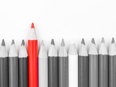 Red pencil standing out from monochrome pencils crowd clipart