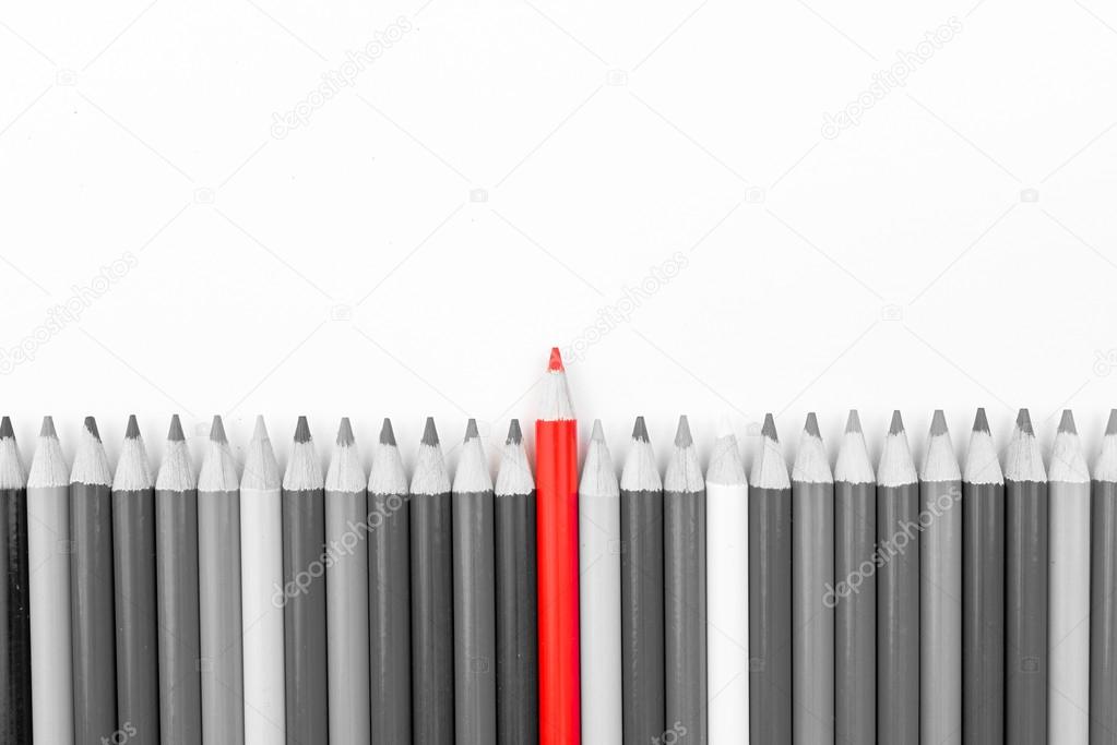 Red pencil standing out from monochrome pencils crowd