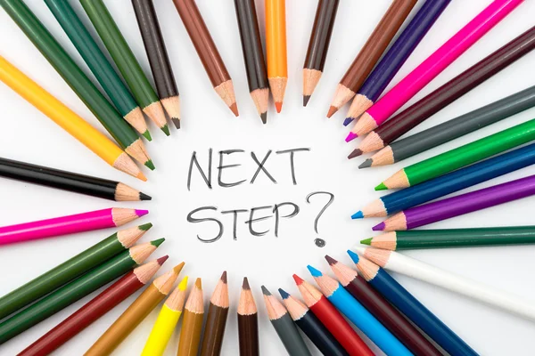 Färgning blyertspennor i cirkel arrangemang med meddelande nästa steg ? — Stockfoto