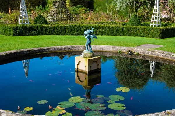 Jardim paisagístico inglês no verão com lagoa e estátua — Fotografia de Stock