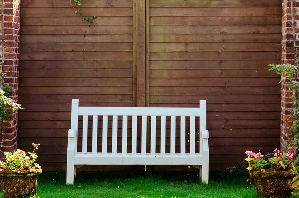 Banc de jardin en bois blanc dans le jardin anglais, filtre de couleur rétro appliqué — Photo