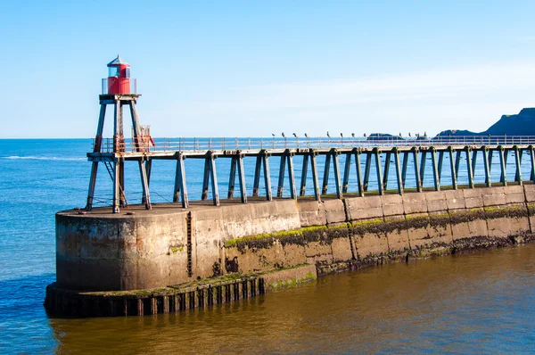 Malerischen Blick auf Whitby Leuchtturm und Pier in sonnigen Herbsttag in North yorkshire, uk. — Stockfoto