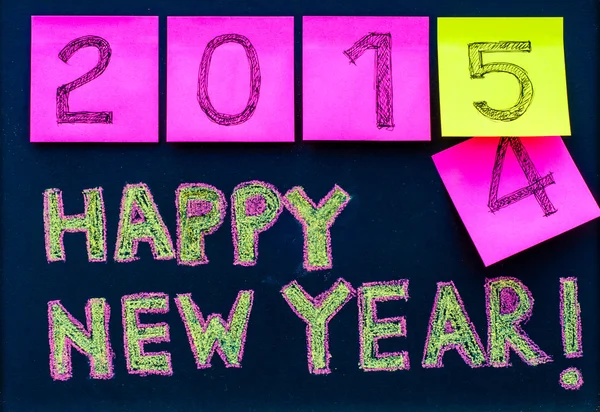 Feliz Año Nuevo 2015 mensaje escrito a mano en pizarra, números indicados en notas post-it, 2015 sustitución de 2014, concepto de celebración de la oficina corporativa —  Fotos de Stock