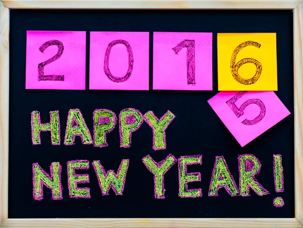 Послание "С Новым 2016 годом!", написанное от руки на доске, цифры, указанные на почтовых банкнотах, 2016 год, заменяющий 2015 год, концепция празднования корпоративного офиса — стоковое фото