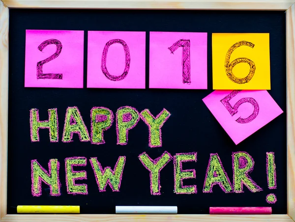 Happy New Year 2016 message hand written on blackboard, numbers stated on post-it notes, 2016 replacing 2015, corporate office celebration concept — Stock Photo, Image