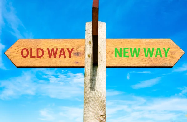 Ahşap tabelasını açık mavi gökyüzü, eski ve yeni yol işaretleri üzerinde iki zıt oklarla hayatını değiştirmek kavramsal görüntü