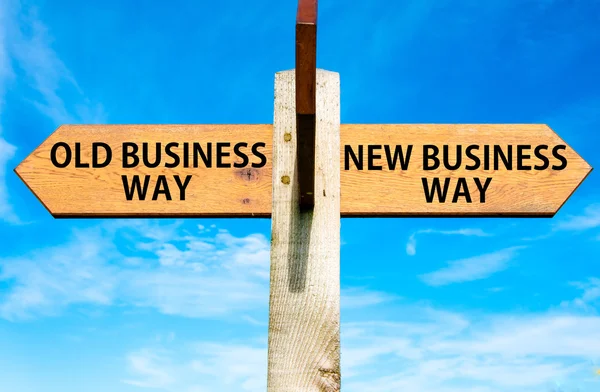 Drewniany drogowskaz z dwóch przeciwnych strzałki przez błękitne niebo, stary biznes sposób i droga nowy biznes, biznes zmienić obraz koncepcyjny — Zdjęcie stockowe