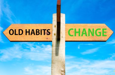 Wooden signpost with two opposite arrows over clear blue sky, Old Habits versus Change messages, Lifestyle change conceptual image clipart