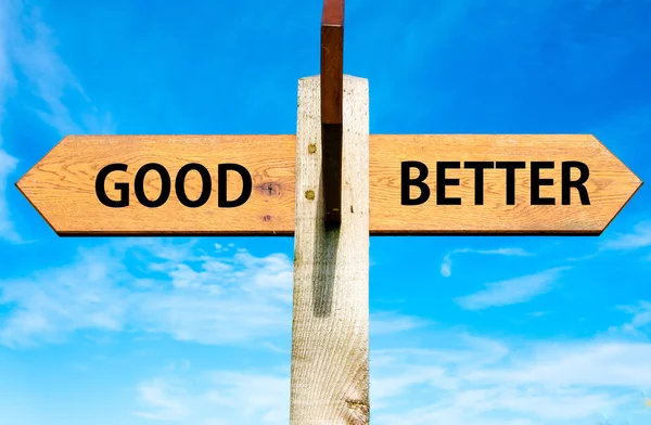 Wooden signpost with two opposite arrows over clear blue sky, Good versus Better messages, Lifestyle change conceptual image — Stock Photo, Image