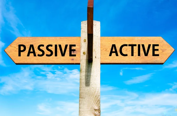 Wooden signpost with two opposite arrows over clear blue sky, Passive versus Active messages, Lifestyle change conceptual image — Stock Photo, Image