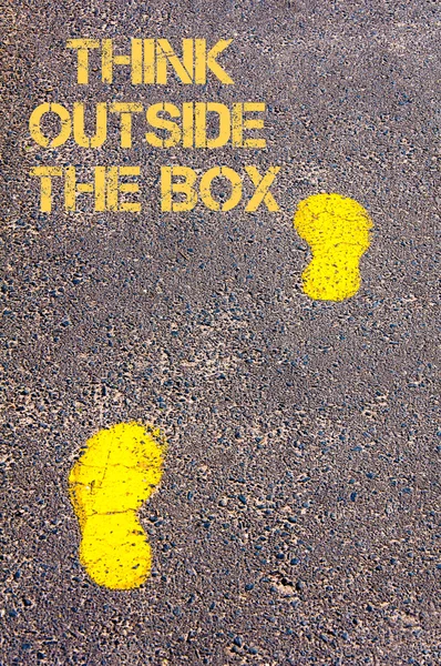 Yellow footsteps on trowalk towards Think Outside The Box message — стоковое фото