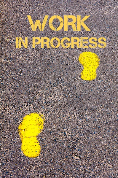 Yellow footsteps on sidewalk towards Work in Progress message — Stock Photo, Image