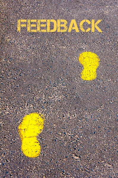 Yellow footsteps on trowalk towards Feedback message — стоковое фото