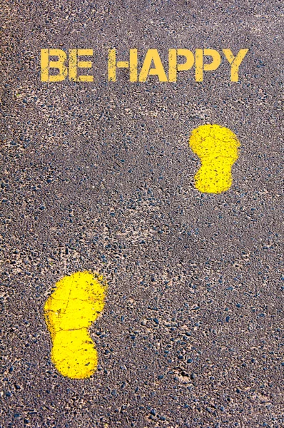 Yellow footsteps on sidewalk towards Be Happy message — Stock Photo, Image