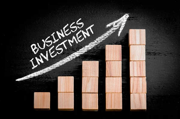 Ord företagens investeringar på stigande pilen ovanför stapeldiagram — Stockfoto