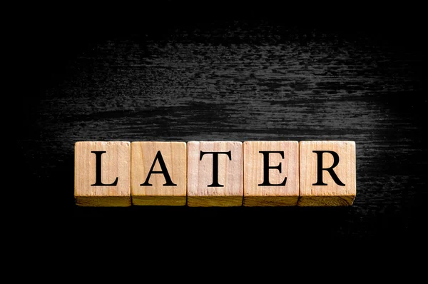 Word LATER isolated on black background with copy space — Stock Photo, Image