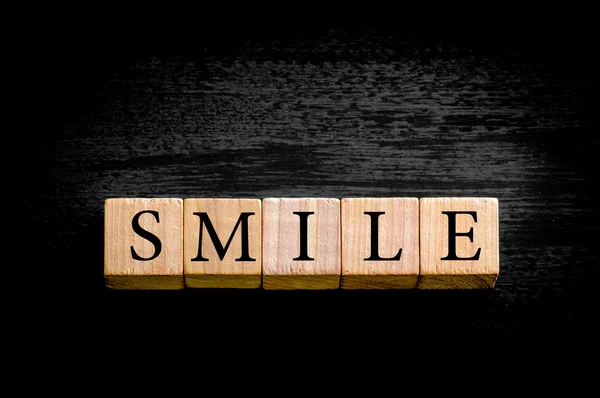Wort Lächeln isoliert auf schwarzem Hintergrund mit Kopierraum — Stockfoto