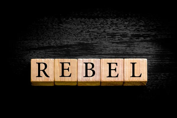 Ordet Rebel isolerad på svart bakgrund med kopia utrymme — Stockfoto
