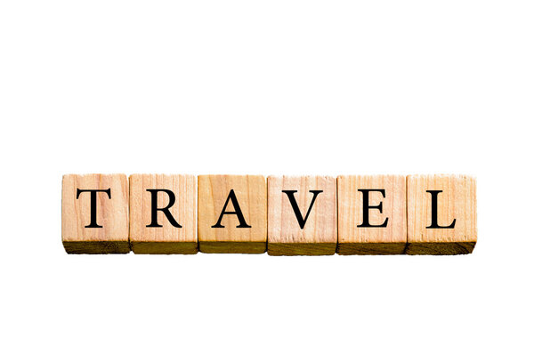 Word TRAVEL. Wooden small cubes with letters isolated on white background with copy space available. Concept image.