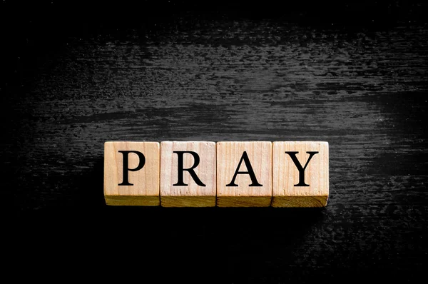 Word PRAY isolato su sfondo nero con spazio di copia — Foto Stock