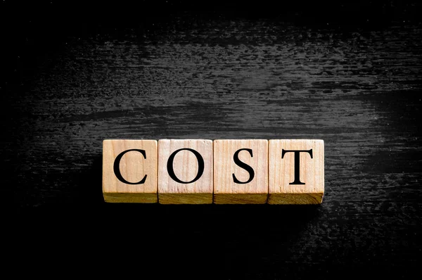 Word COST isolated on black background with copy space — Stock Photo, Image