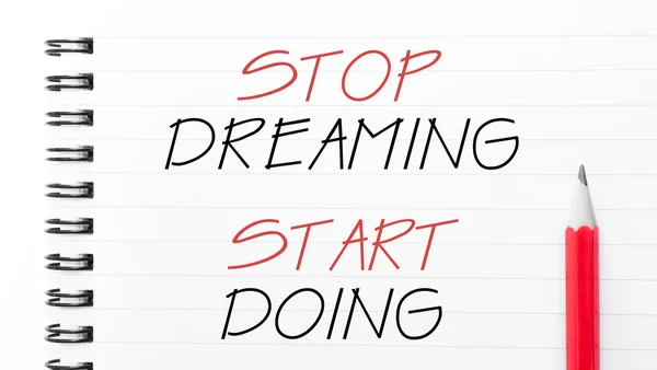 Stop Dreaming Start Doing написано на сторінці ноутбука — стокове фото