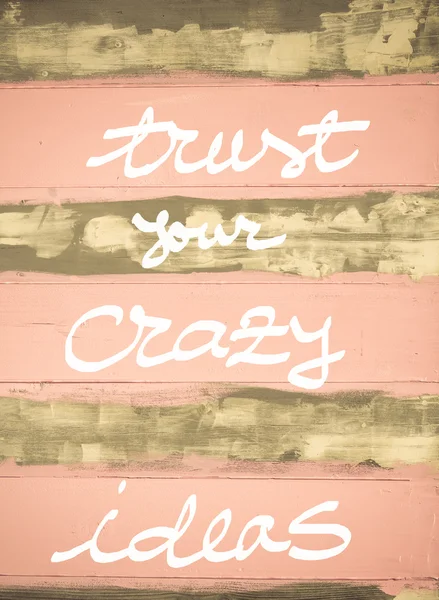 Concept image of Trust Your Crazy Ideas cita motivacional escrita a mano en la pared de madera pintada vintage — Foto de Stock