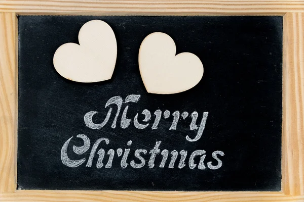 Cadre en bois tableau noir vintage avec message de Joyeux Noël et deux formes de coeur — Photo