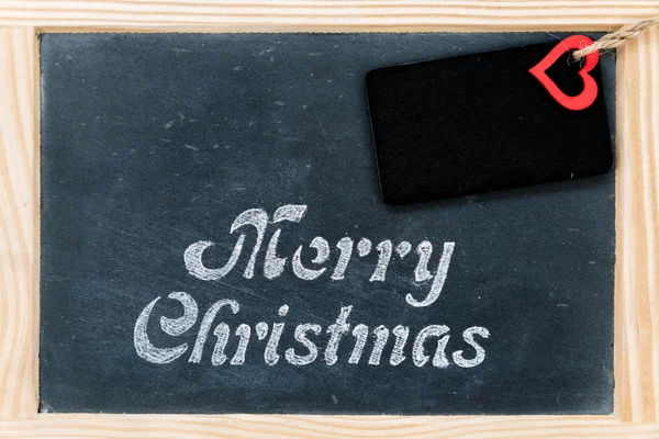 Quadro de madeira chalkboard vintage com mensagem Feliz Natal, tag e forma de coração vermelho — Fotografia de Stock