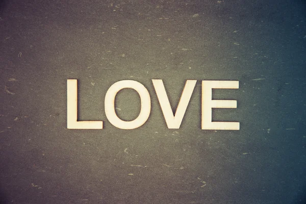 Λέξη αγάπη δημιουργήθηκε από ξύλινα γράμματα πάνω από vintage μαυροπίνακα, ρετρό φίλτρο εφαρμοσμένο, εννοιολογική εικόνα — Φωτογραφία Αρχείου