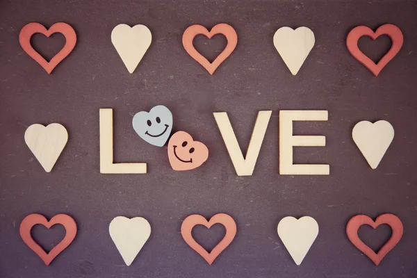 Винтажная доска со Словом ЛЮБОВЬ, созданная из деревянных букв и очертаний сердца вокруг — стоковое фото