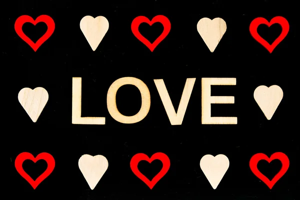 Palavra AMOR criado de letras de madeira sobre chalkboard vintage, com símbolos de forma de coração vermelho — Fotografia de Stock