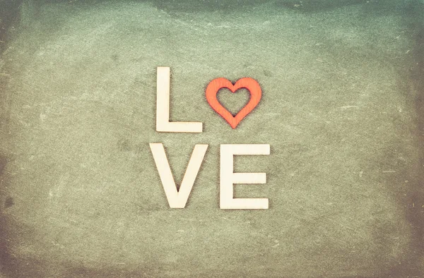 Vintage tabuli s slovem láska vytvořené z dřevěných písmen, retro použit filtr — Stock fotografie