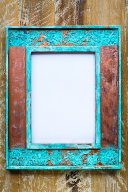 Vintage photo frame over wood background with empty white canvas
