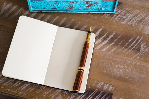 Classic fountain pen and open notebook on wooden table — Stock fotografie