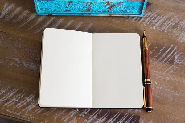Classic fountain pen and open notebook on wooden table — Stock fotografie