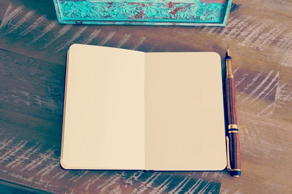Caneta-tinteiro clássica e caderno aberto na mesa de madeira — Fotografia de Stock