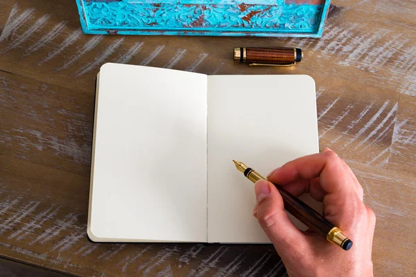 Efeito retrô e imagem tonificada de uma mulher mão escrevendo uma nota com uma caneta-tinteiro em um caderno . — Fotografia de Stock