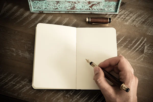 Effetto retrò e immagine tonica di una donna che scrive una nota con una penna stilografica su un quaderno . — Foto Stock