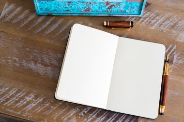 Classic fountain pen and open notebook on wooden table 