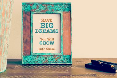 Motivational quote written on vintage photo frame 