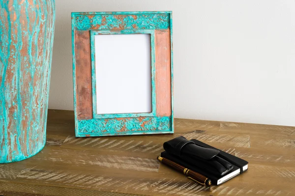 Vintage photo frame on wooden table over white wall background