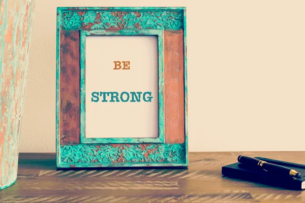 Motivational quote written on vintage photo frame BE STRONG — 스톡 사진